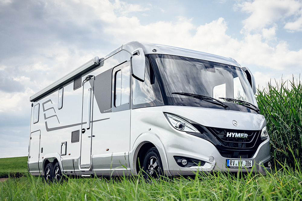 Niesmann Caravaning bietet junge Gebrauchte zu attraktiven Sonderkonditionen. Ein weißes Wohnmobil steht vor einem Maisfeld.